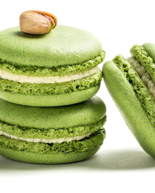 Small macaroons with pistachio on white background